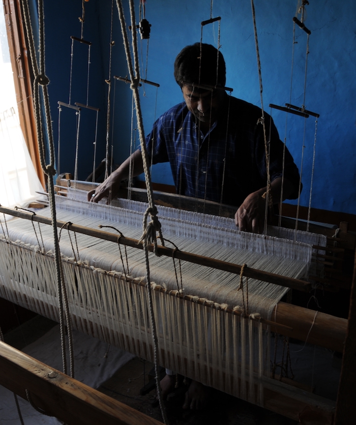 Kashmiri weaver on his traditional wooden loom