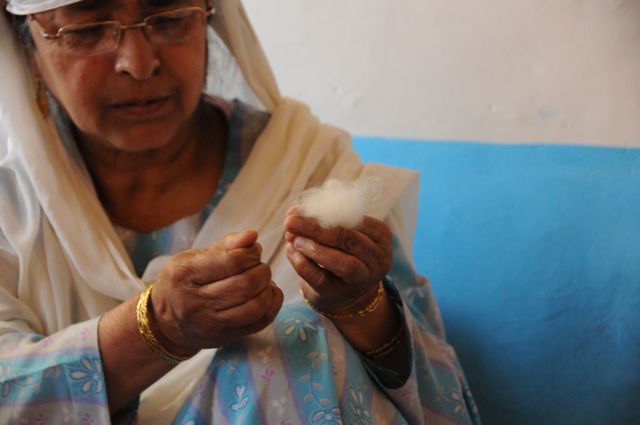 La pashmina es hilada a mano por mujeres Mujer sujetando una pashmina de cachemira