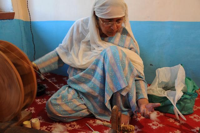 Mujer hilando cachemira con una rueca